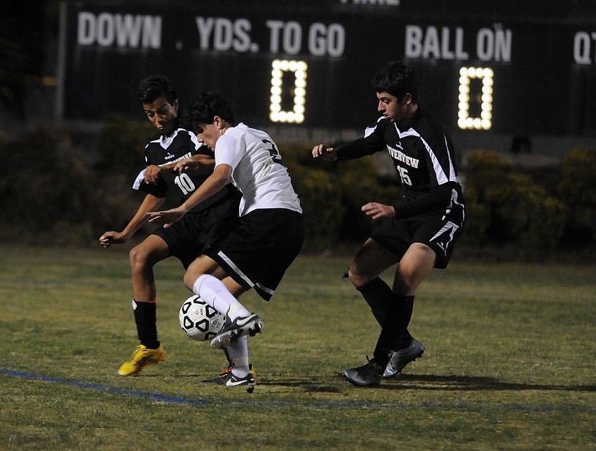 Lakewood Ranch forward Ricky Yanez battles Riverview's Felipe Rojas and Adi Trifka for possession in the first half.