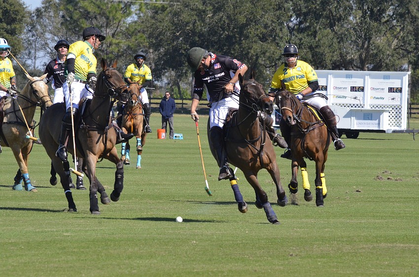 Southside Polo player Matt Sekera reaches for the ball.