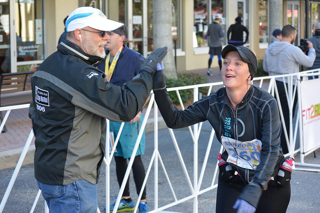 Lakewood Ranch's Angela Abrams shows relief as she high-fives finish line coordinator Roger Raddatz after completing the Suncoast Half Marathon. Would the community embrace a bigger event?