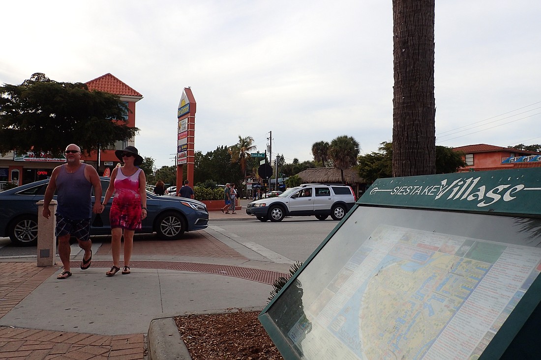 Beachgoers stroll the Siesta Key Village, where parking is often difficult to find.