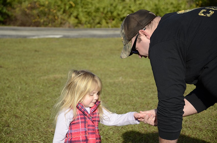 Carly Kennedy gets her hands warmed up and her snow gear—a hat and mittens— put on by her uncle Chandler Hartman.