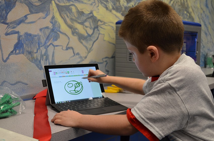 Frank Billiteri plays on a tablet in the newly dedicated Shooting Star Lab at Ashton Elementary School.