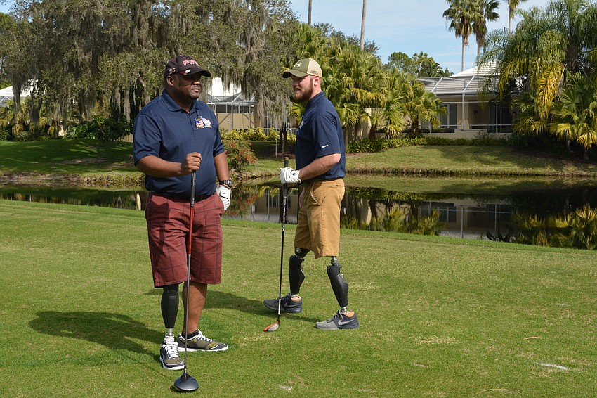 Army Staff Sgt. Christopher Gordon gets some encouraging words from Marine Corp. Josh Langston-White before teeing off at Rosedale Golf and Country Club.