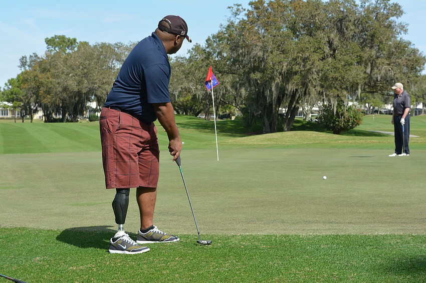 Army Staff Sgt. Christopher Gordon puts the ball on track at the first green in the Homes For Our Troops golf tournament at Rosedale Golf and Country Club.