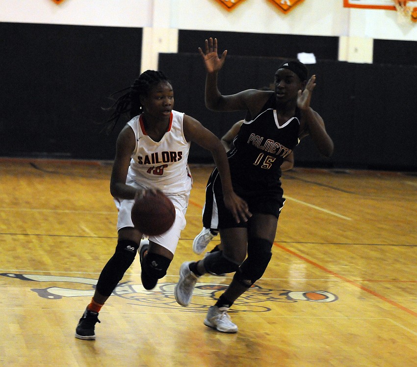 Sarasota sophomore Imani Jones attempts to dribble around Palmetto's Tina Stephens.