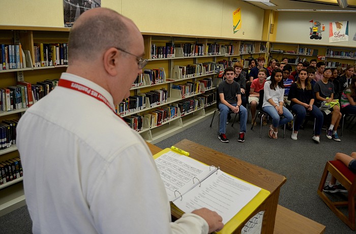 Social studies teacher Chris Brown asks students questions during the sixth round of the competition.