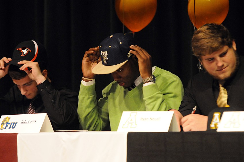Kicker Kyle Thoma and defensive back JoJo Louis put on their college hats after signing letters-of-intent.