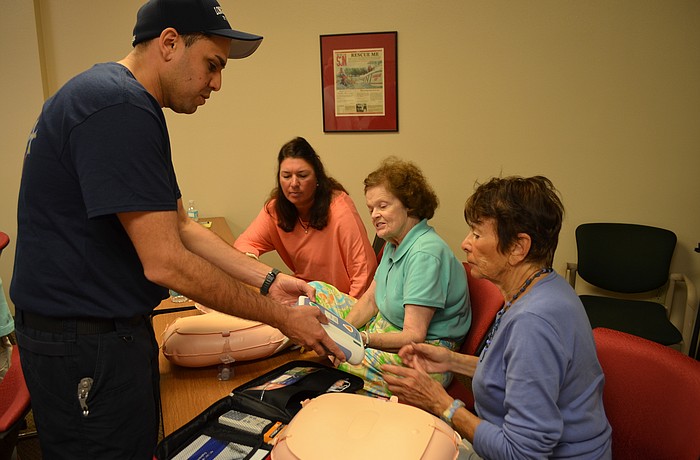 Firefighter/paramedic Jose Rivera  teaches Bayport residents Chris Lake, Arlene Scarlett and Sue Rosen how to use an automatic external defibrillator Feb. 3 at the north fire station.