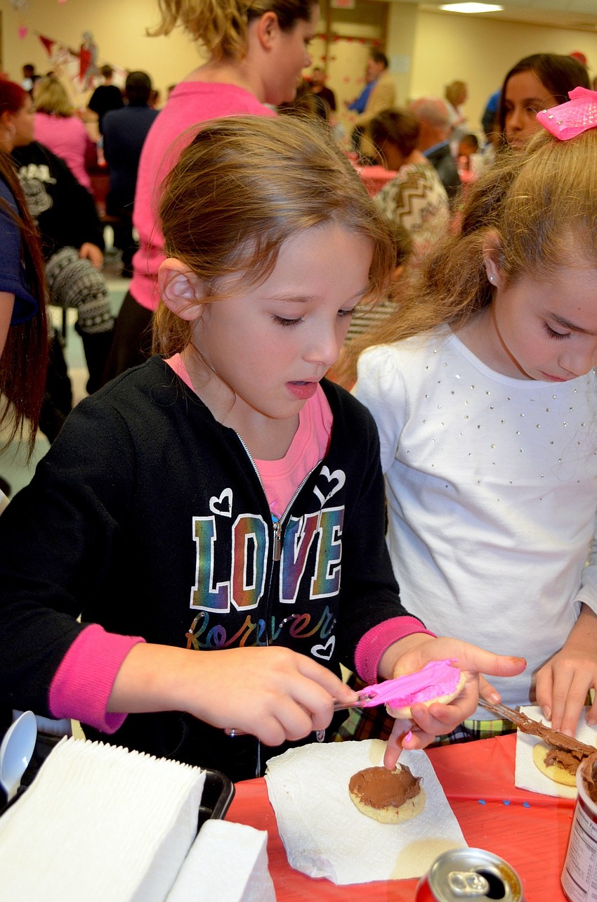 Ashlynn Henry visits the cookie decorating table.