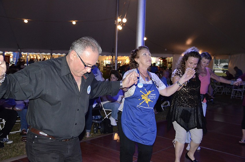 Volunteers and vendors Steve Zeris, Diane Kontonickas and Mary Duvalris dance for a crowd.