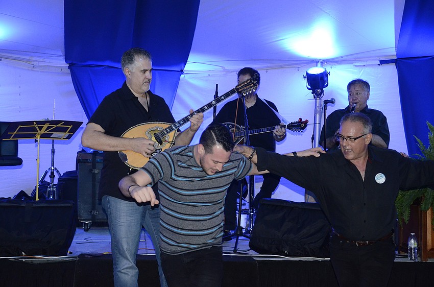 George Karras plays the bouzoki with the band while Christian Lykiardopoulos of Bradenton and Steve Zeris, volunteer, dance.