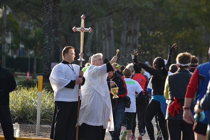 Nick Nichols and the Rev. Richard Marsden bless runners on the sixth mile of the Sarasota Music Half Marathon.