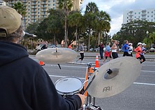 Gavin Michael plays drums for Kettle of Fish as participants race by.