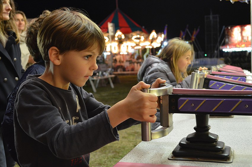 Bert Votruba and Stella Votrubova compete in a water gun carnival game.