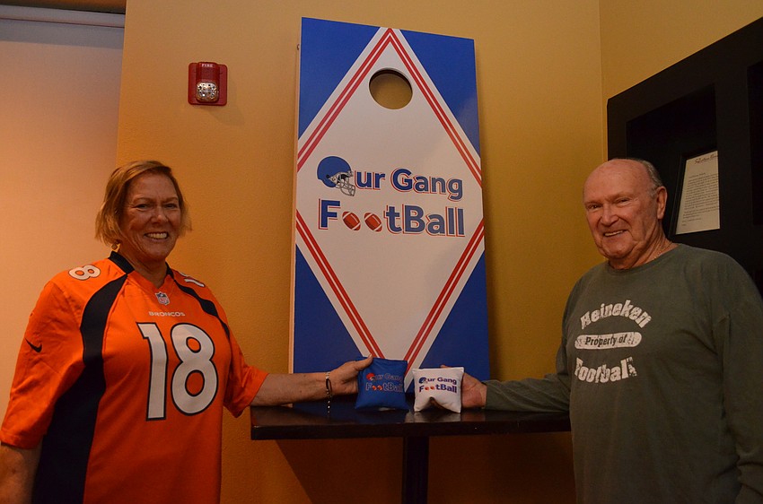 Party hosts Tinker and Tony Britton were surprised with a customized cornhole game with the group's logo.