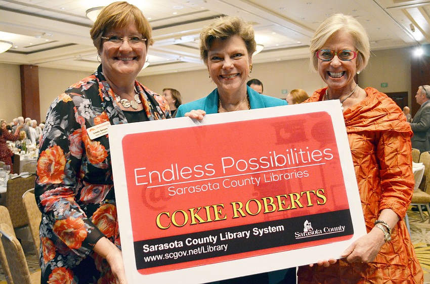 Library Foundation of Sarasota County President Linda Getzen presented featured speaker Cokie Roberts with a library card alongside Community Foundation President and CEO Roxie Jerde.