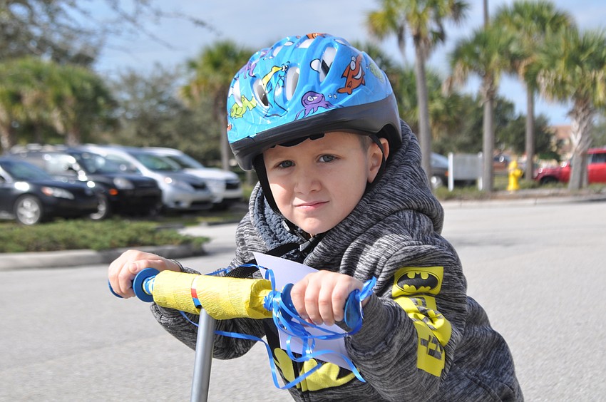 Lucas Estep races with his classmates on a scooter.