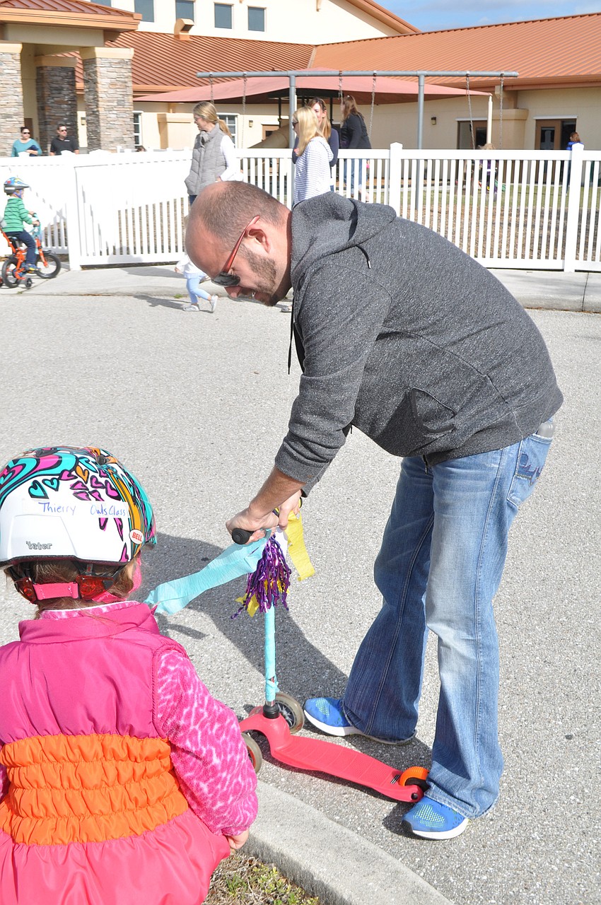 Father of Kallie Granquist, Tim Granquist helps repair Thierry Ames' scooter.
