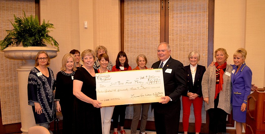 Bobbie and Doug Wagner accept a donation on behalf of Stillpoint House of Prayer, a food pantry in downtown Bradenton.