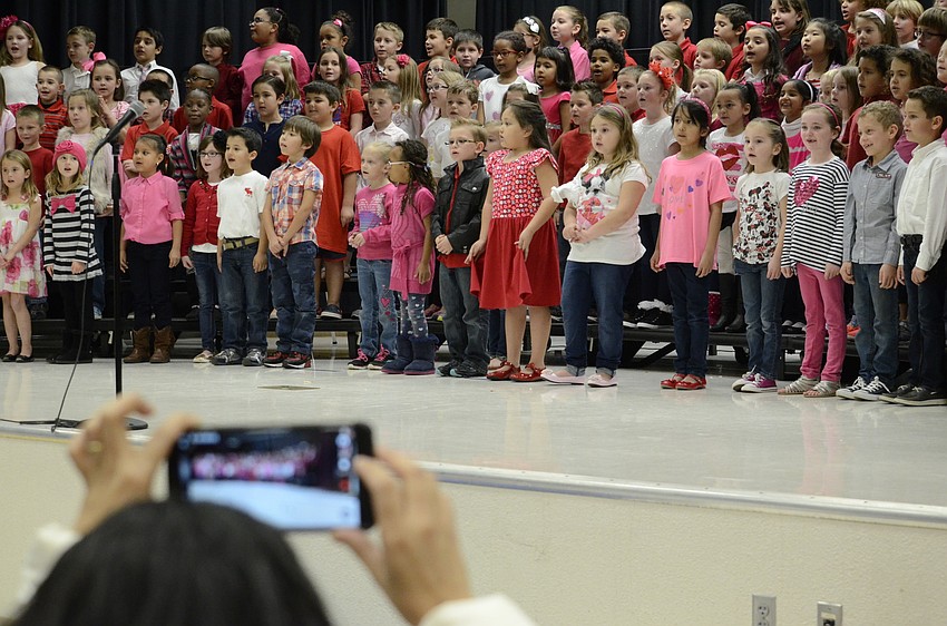 Parents and family record the first-graders performance about Valentine's Day.