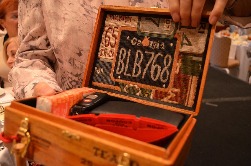 Jane Slaughter opens up her cigar box purse to reveal a Georgia license plate embroidery.