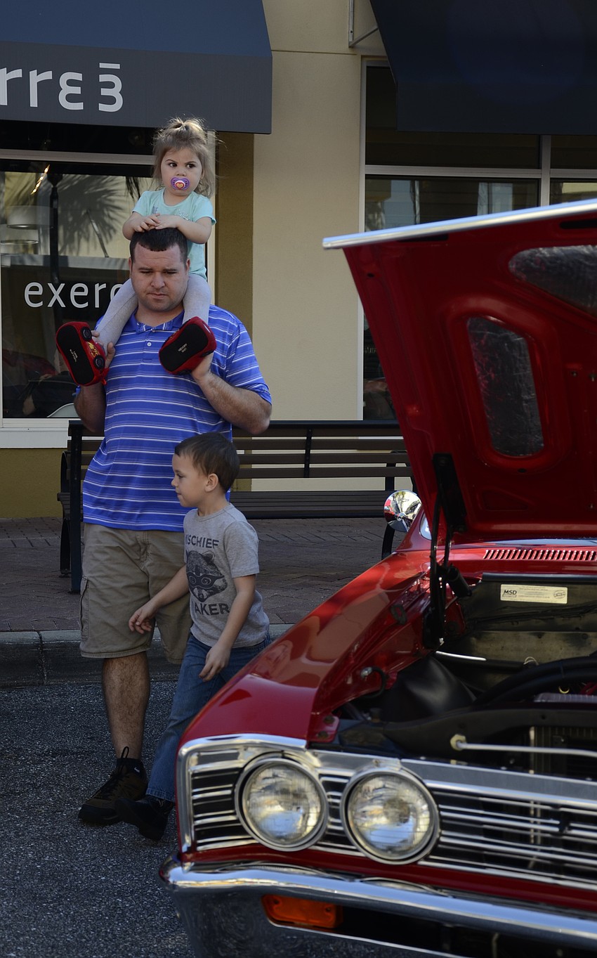 Gracie, John and Matthew Vajanyi of Lakewood Ranch admire a 1971 Pontiac Firebird.