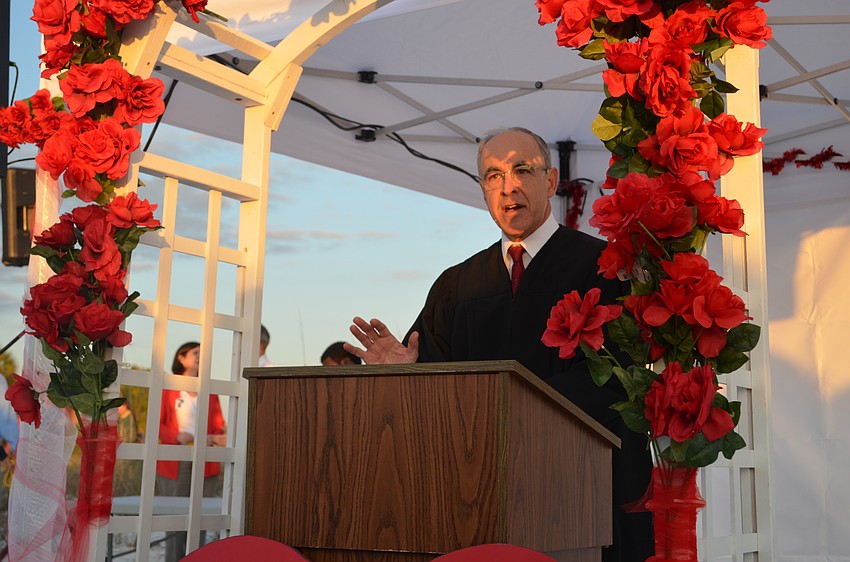 Judge Charles Roberts reads vows for couples during the Say ‘I do’ Again ceremony Feb. 14 at Siesta Key Beach.