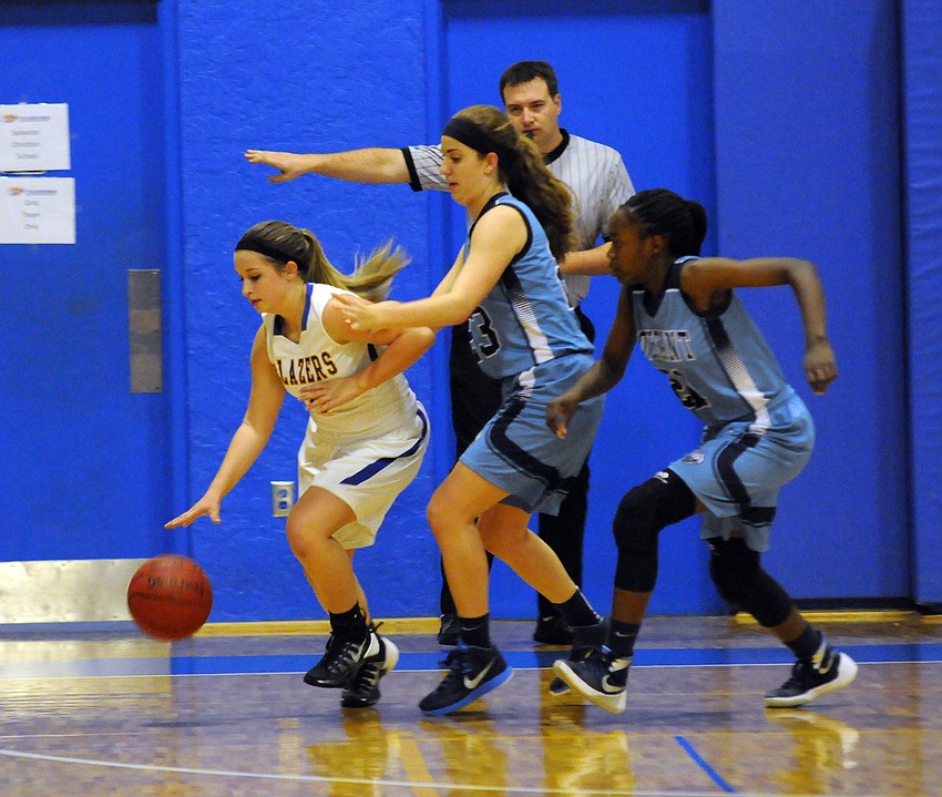 Sarasota Christian sophomore Alyssa Schrag attempts to dribble the ball around a pair of Palm Bay Covenant Christian defenders.