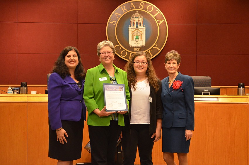 Sarasota County Commissioner Christine Robinson presents a proclaimation celebrating the 20th anniverary of CYD to CEO Karen Bogues, Sarah Marin and former commissioner Shannon Staub.