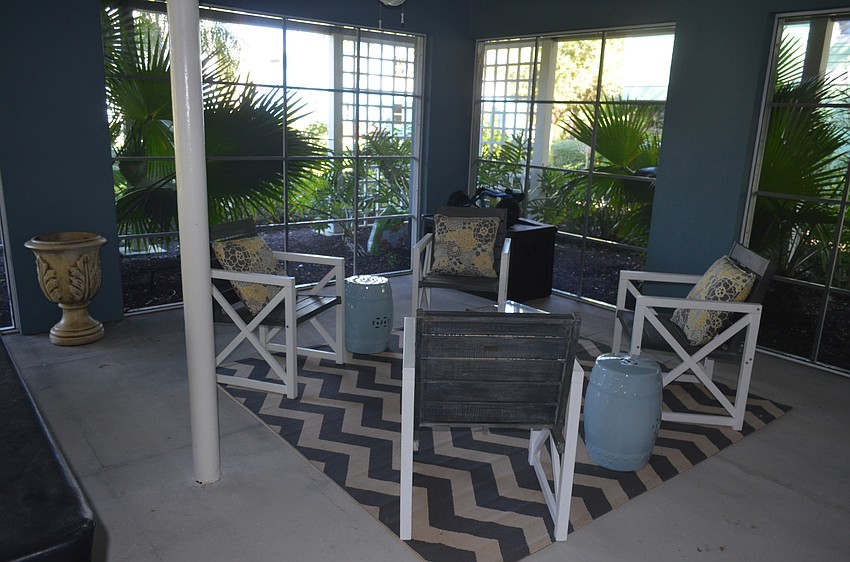 Beneath the main level is a screened-in patio area with chairs and a pool table.