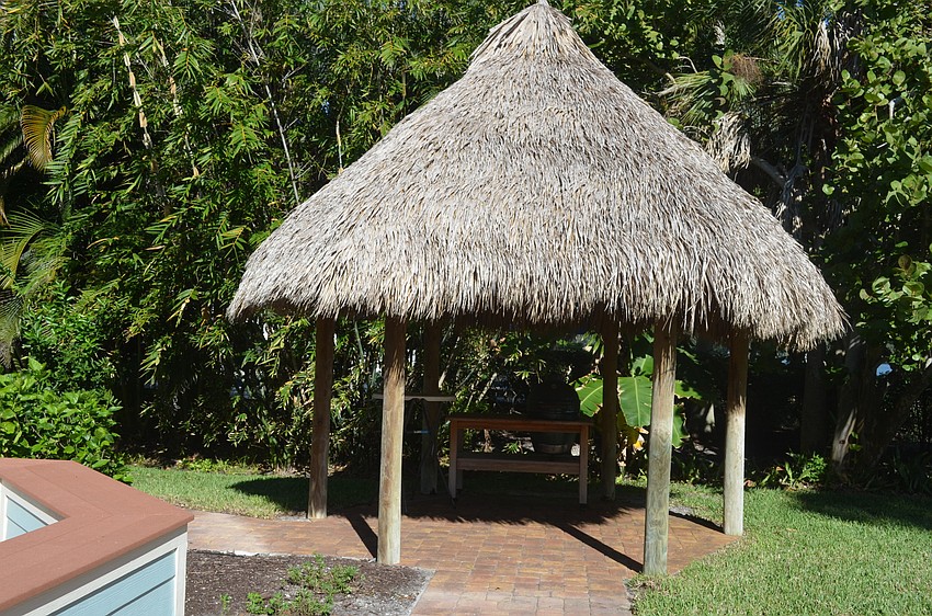 A tiki hut in the backyard provides a shaded area to eat and relax.