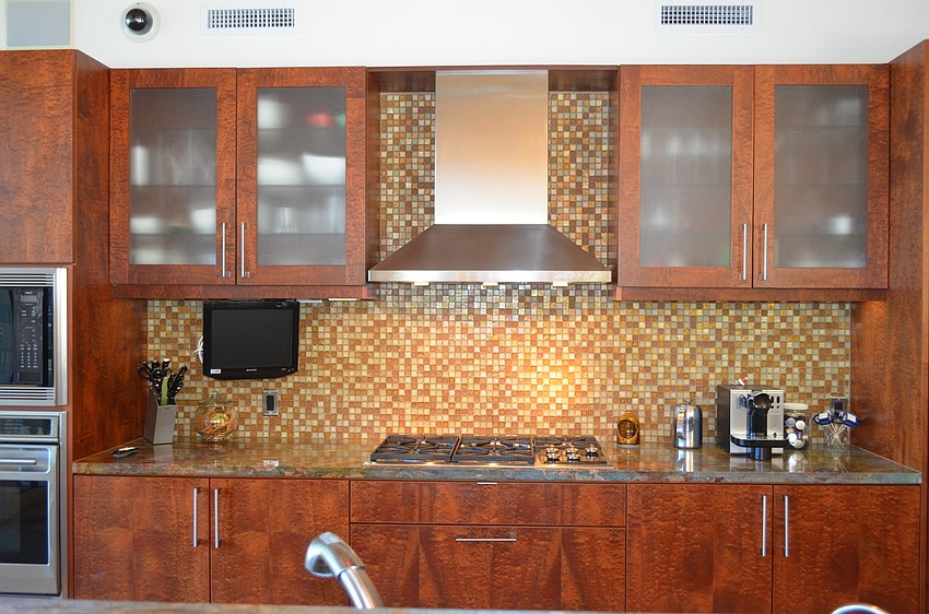 The kitchen was designed to optimize workflow and has long granite countertops and mosaic walls.