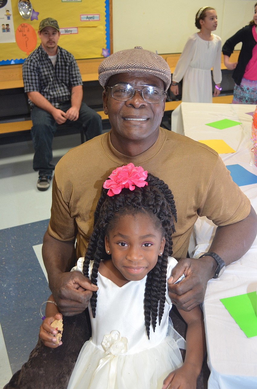 Thomas Sams and his goddaughter, Kamisa Goldman, enjoy snacks before dancing.