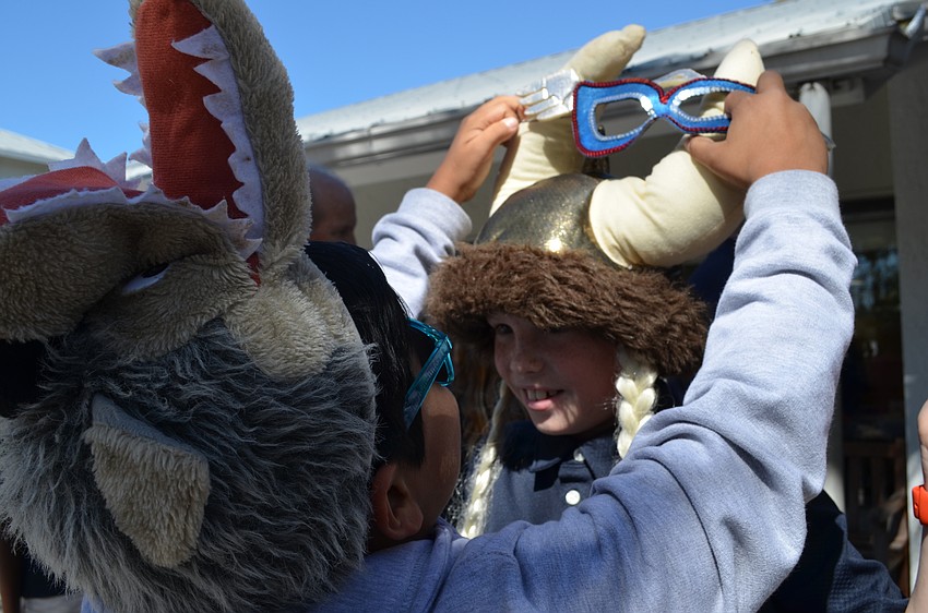 Arlo helps his friend David slip on Captain America goggles on top of his viking helmet.