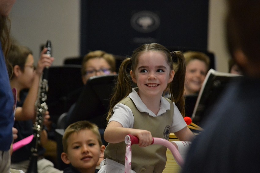 Rowan rides in on a bicycle during a performance for grandparents and friends at Out-of-Door Academy.