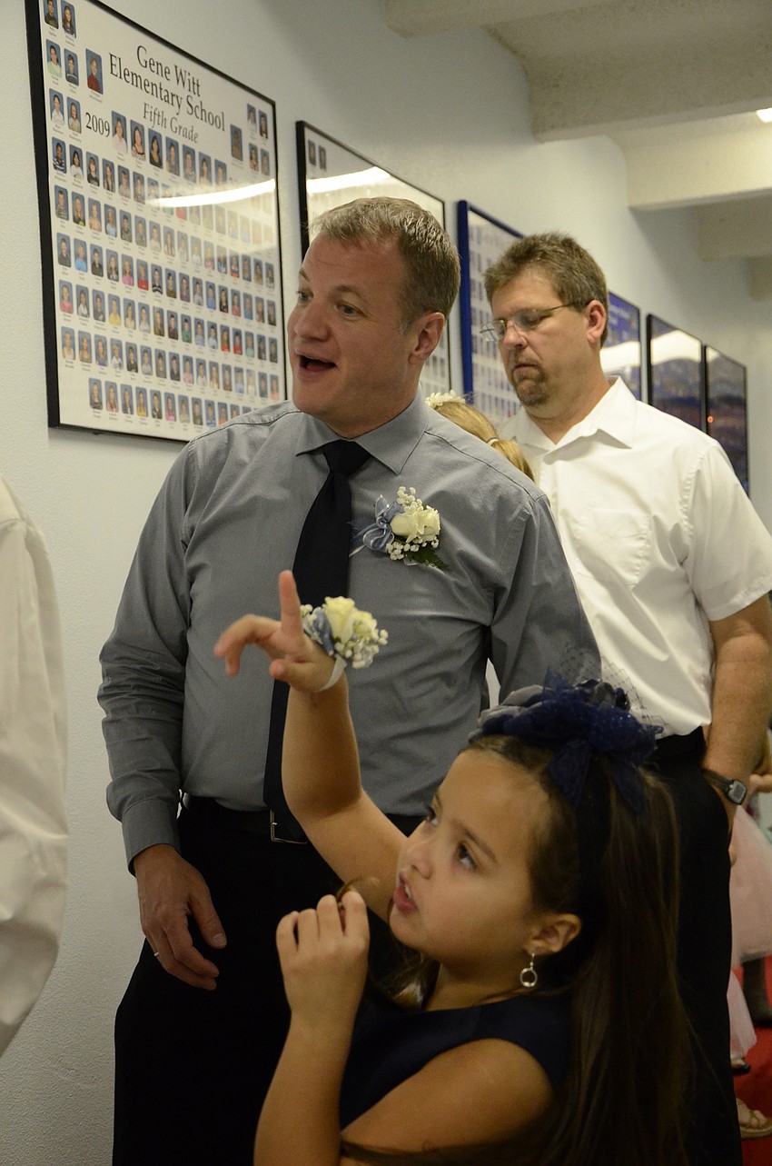 John and Anna Wompey talk about the class portraits on the wall.
