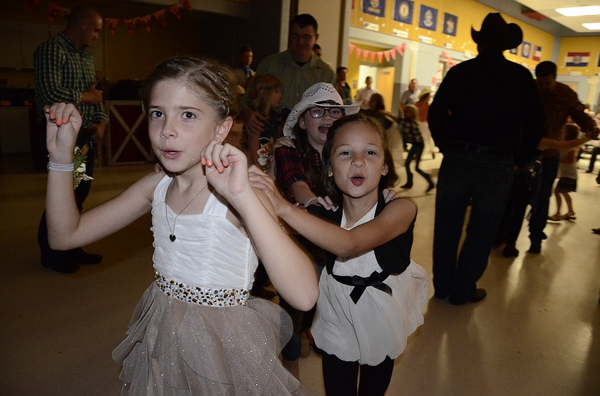 Paige Dewitt, Olivia Weaver and Shelby Durrant lead a train around the cafeteria.