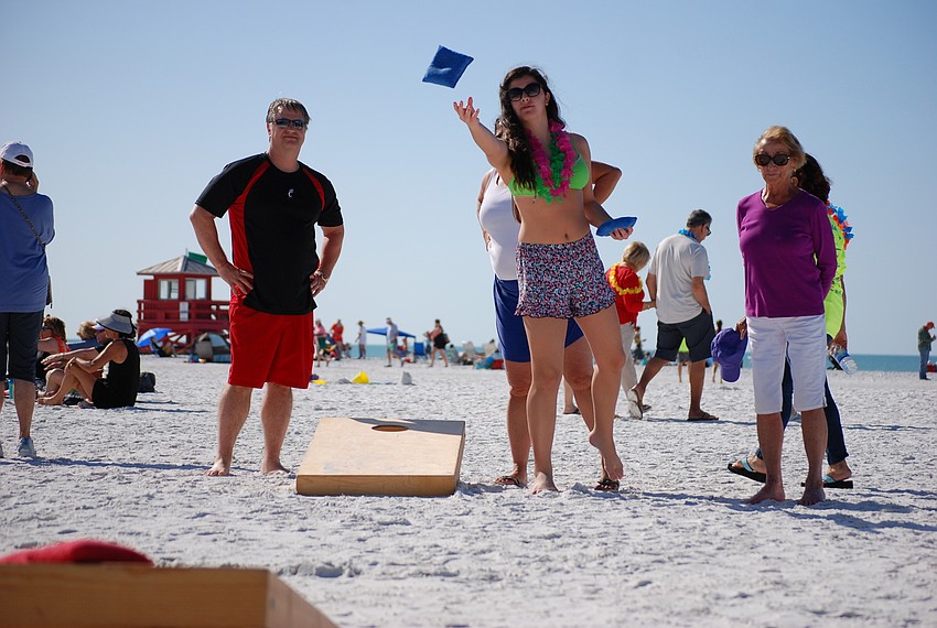 Olivia Picotte throws a bag in a friendly game of cornhole with Bob and Lora Gray, and Barbara Glidden