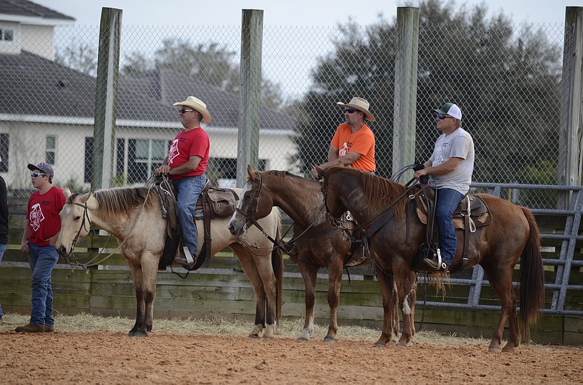 Some cowboys watch their friends compete.