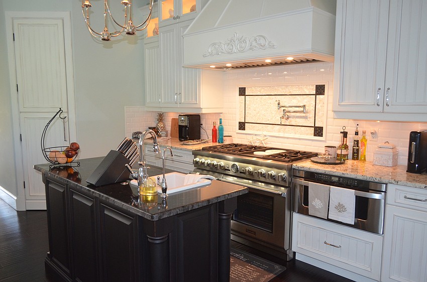 The kitchen features Thermidor appliances and white cabinetry by J.C. Mack & Associates.