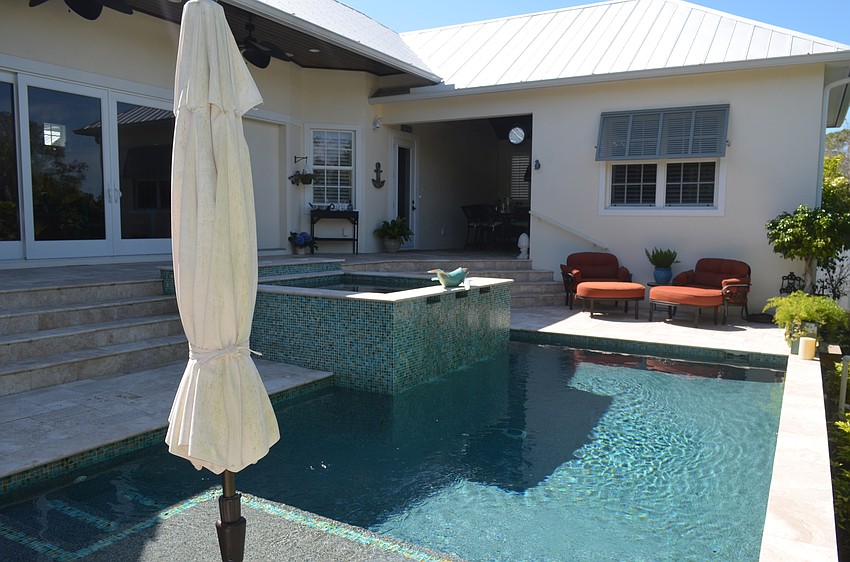 The backyard area features a pool, hot tub, sunken fire pit and sitting areas.