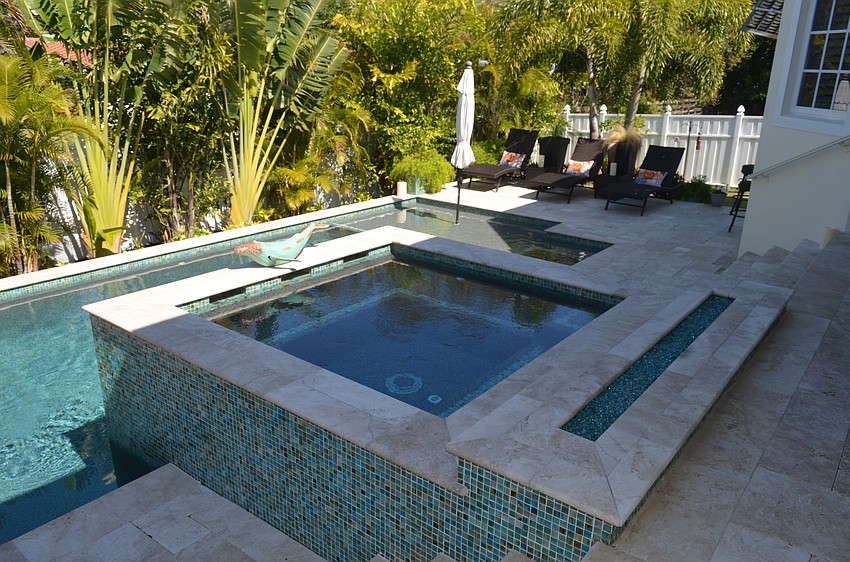 The backyard area features a pool, hot tub, sunken fire pit and sitting areas.