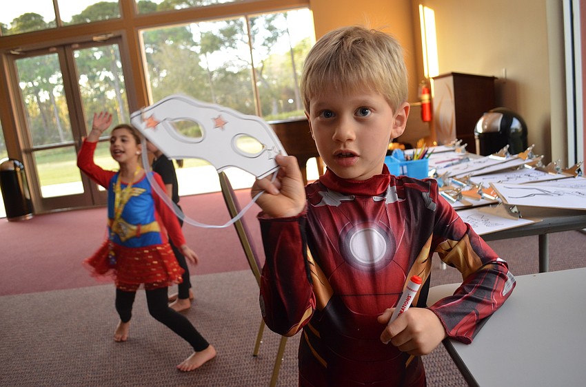 Zachary Kurnov colors in a superhero mask to match his Ironman costume.