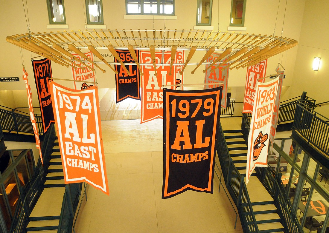 Fans are greeted by a baseball bat chandelier when they walk through the doors of Ed Smith Stadium. The flags are representative of the Orioles championships.