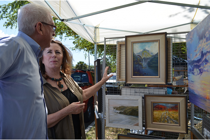 Artist HC Morgan talks with Diana Butler at the 2015 Sun Circle Art Festival.