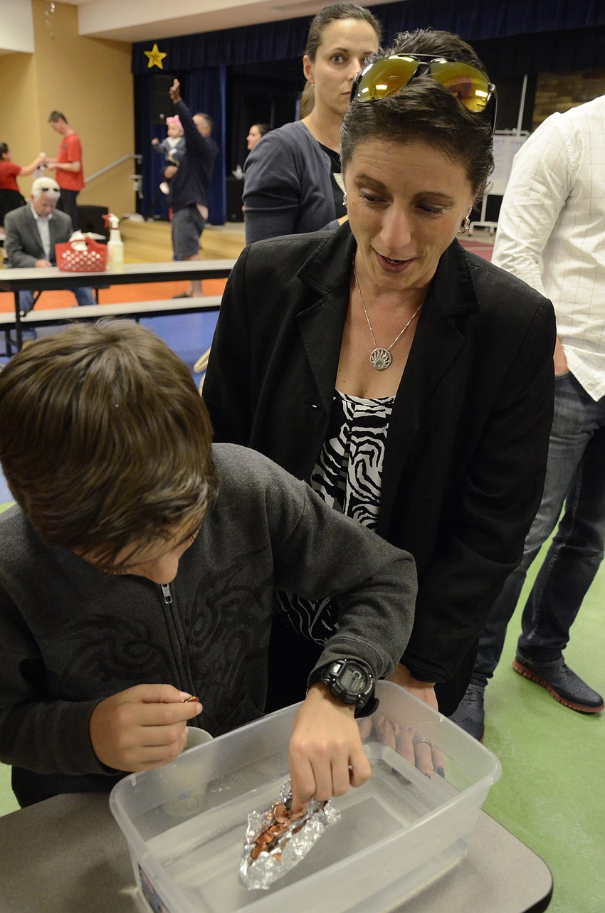 James and Lisa Wilmeth see how many pennies their aluminum foil boat will hold.