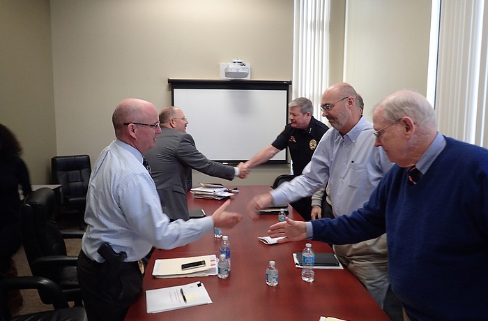 Clockwise, Police union representative Sgt. Robert Bourque and attorney Jim Brantley shake hands with Police Chief Pete Cumming, Town Manager Dave Bullock and Town Labor Attorney Reynolds Allen after negotiations.