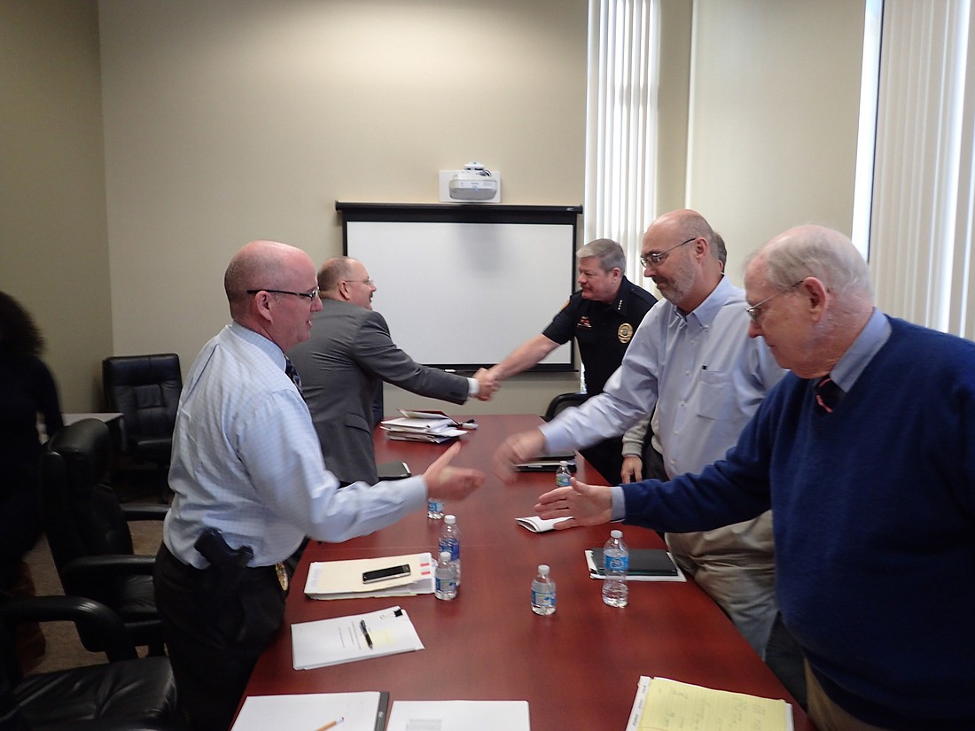 Clockwise, Police union representative Sgt. Robert Bourque and attorney Jim Brantley shake hands with Police Chief Pete Cumming, Town Manager Dave Bullock and Town Labor Attorney Reynolds Allen after negotiations.