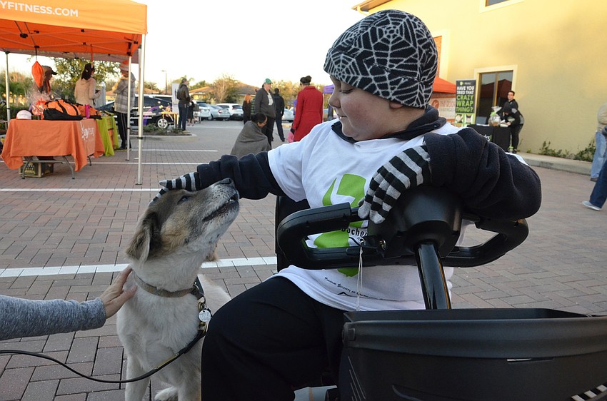 Grayson Tullio of Lakewood Ranch pets Gandolph the rescue pup, also of Lakewood Ranch.