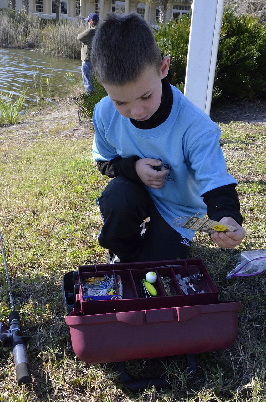 Cody Schlise of Riverview hunts through the tacklebox. He and his family visited his grandmother, Janet Cole, in Lakewood Ranch.